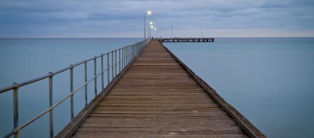 a pier with lights on at the end